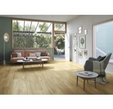 Ljust vardagsrum med trägolv, soffa och utsikt över trädgården