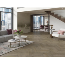 Ljust vardagsrum med soffa, bord och fiskbensparkett