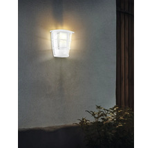 Belyst vit utomhusvägglampa på en vägg