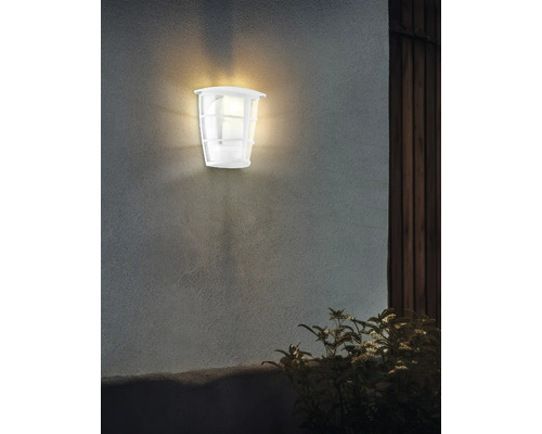 Belyst vit utomhusvägglampa på en vägg