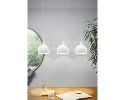 Pendellampa med tre lampor ovanför ett träbord