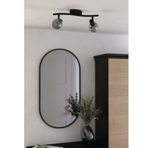 Taklampa med två lampor och oval spegel i ett ljust rum