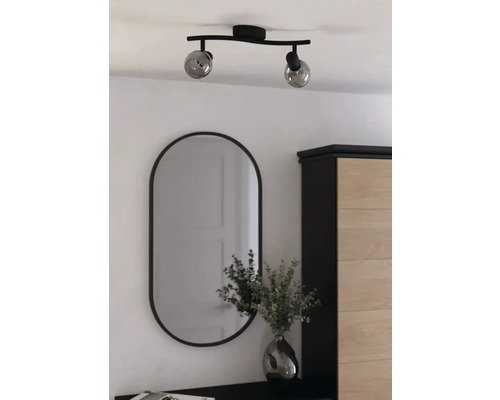 Taklampa med två lampor och oval spegel i ett ljust rum