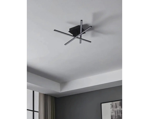 Modern taklampa med korsade LED-ljusstavar i vardagsrummet