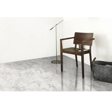 Ljust rum med golv i marmorlook, stol, golvlampa och korg