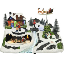 Vinterminiatyrlandskap med hus, bäck, figurer och roterande jultomtesläde