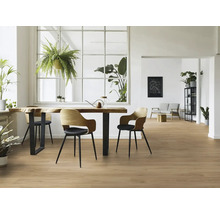 Ljust rum med trägolv, matbord, stolar och krukväxter