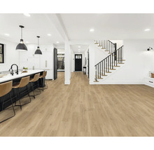 Ljust rum med öppet kök, trappa och vinylgolv med träutseende.