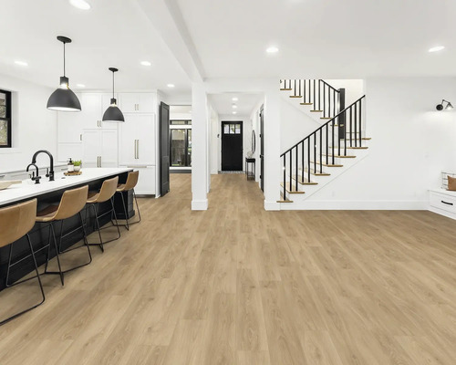 Ljust rum med öppet kök, trappa och vinylgolv med träutseende.