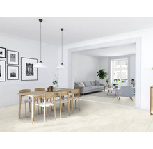 Ljust vardagsrum med matbord, stolar och klinkergolv