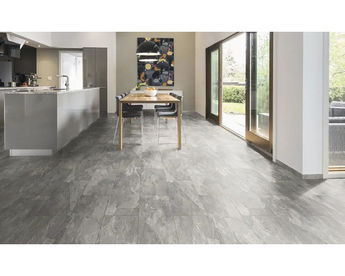 Ljust rum med köksö, matbord och grått golv med kakeldesign