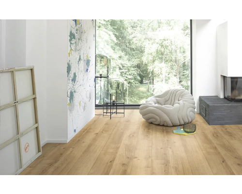 Ljust rum med laminatgolv, fönster, sittplats och dekoration