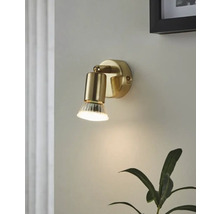 Guldfärgad vägglampa med klar glasdiffusor monterad på en vägg.