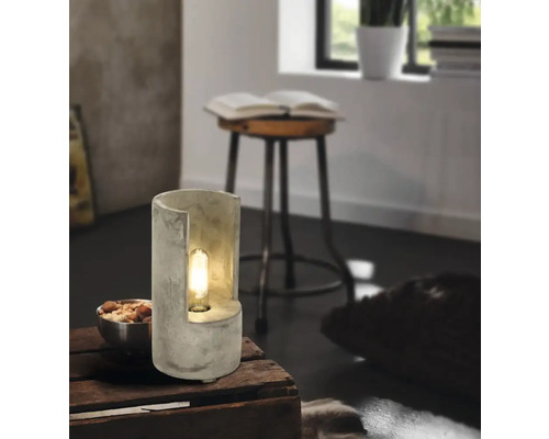 Dekorativ bordslampa i betong med glödlampa i ett vardagsrum