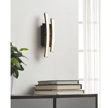 Vägglampa med tre vertikala, ojämna ljuselement i modern design