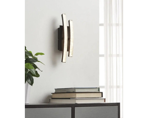 Vägglampa med tre vertikala, ojämna ljuselement i modern design