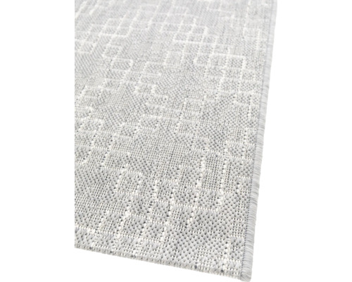 Detaljvy av en ljus matta med geometriskt mönster