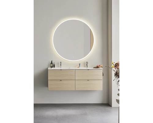 Modernt badrum med tvättställsskåp, tvättställsskål och rund spegel med belysning