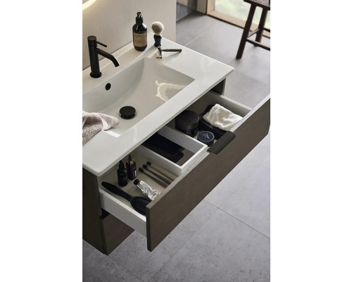 Badrumskommod med öppna lådor för förvaring av badrumsartiklar.