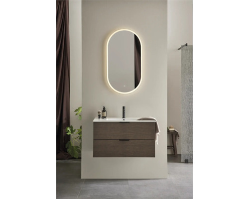 Badrum med tvättställsskåp, tvättställsskål, armatur och belyst spegel