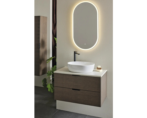 Modernt badrum med tvättställsskåp, tvättställsskål och belyst spegel