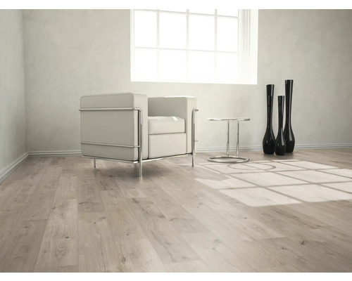 Ljust rum med laminatgolv, fåtölj, bord och dekorativa vaser.