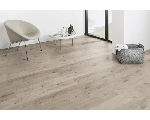 Ljust vardagsrum med laminatgolv, stol och korg