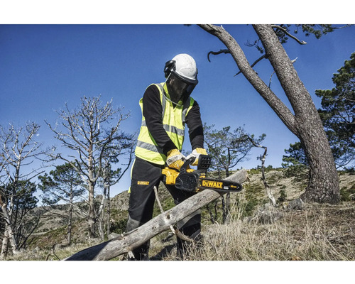 En person med skyddsutrustning sågar en trädstam med en DeWalt motorsåg.