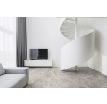 Ljust vardagsrum med spiraltrappa, TV och soffa.