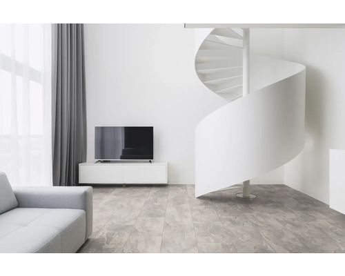 Ljust vardagsrum med spiraltrappa, TV och soffa.