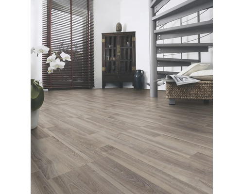 Ljust rum med laminatgolv, mörkt träskåp och spiraltrappa