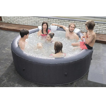 Familj kopplar av i uppblåsbar bubbelpool i trädgården