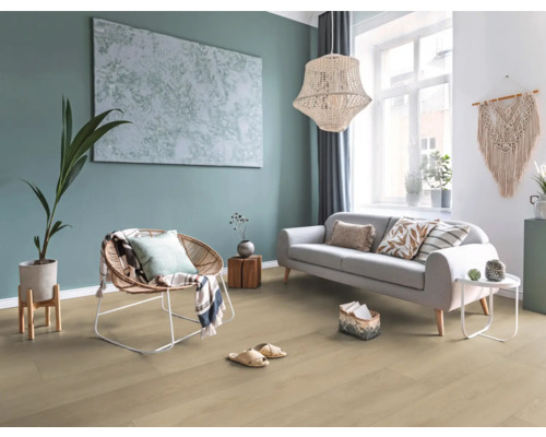 Ljust vardagsrum med soffa, fåtölj, dekoration och trägolv