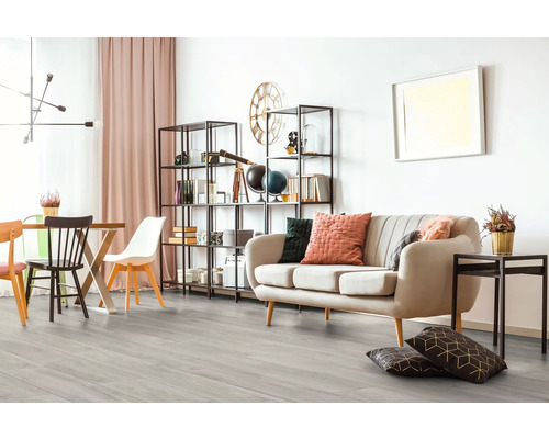 Vardagsrum med soffa, bokhylla och matbord på trägolv