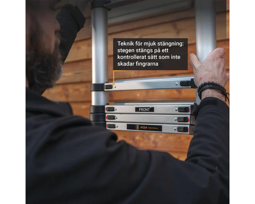 Närbild av en teleskopisk stege som demonstrerar en mjukstängningsfunktion, där stegen stängs på ett kontrollerat sätt för att förhindra fingerskador.