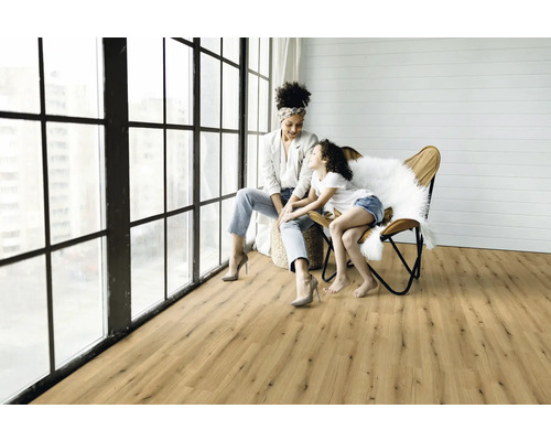 Ljust vardagsrum med trägolv och mamma med barn vid fönstret