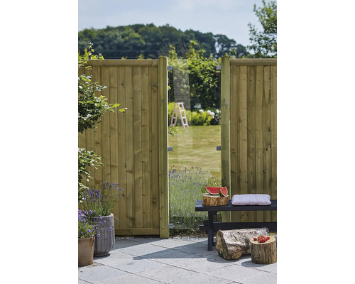 Trädgårdsscen med trästaket, glaselement och sittbänk