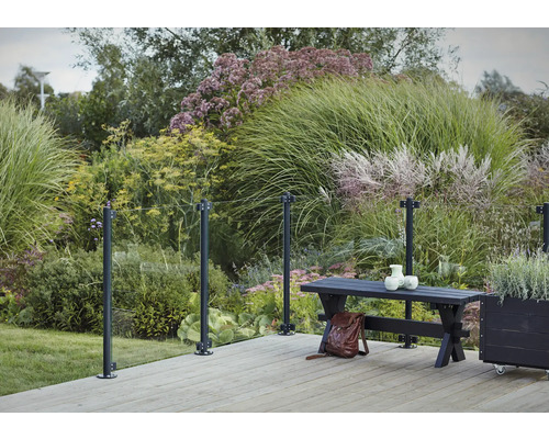 Terrass med glasräcke, bänk och frodig grönska