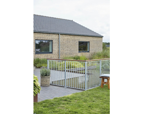 Terrassstaket av metall och trä framför ett bostadshus