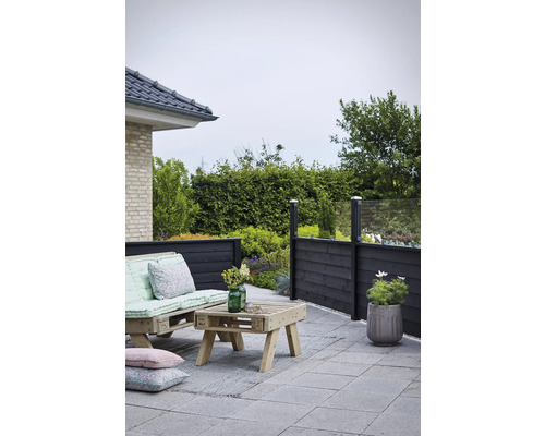 Terrassdesign med trämöbler, insynsskydd och gatstenar