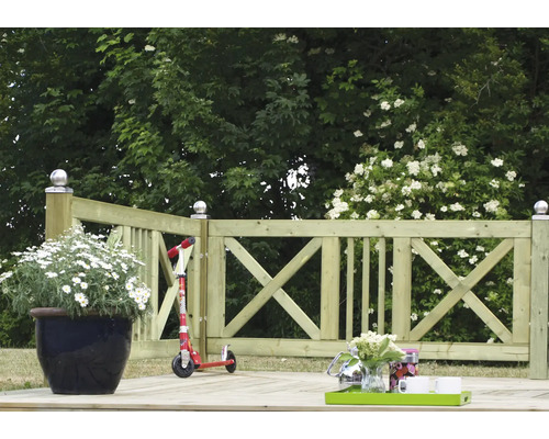 Träterrass med räcke, blomkruka och sparkcykel