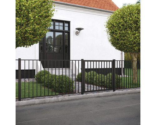 Svart metallstaket med grind framför ett hus