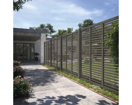 Trädgårdsstaket med horisontella lameller framför ett hus.