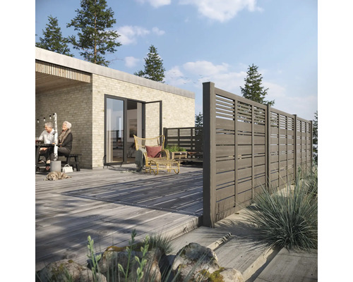 Scen med insynsskydd, trädäck och trädgårdsmöbler framför ett bostadshus