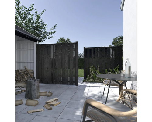 Scen med ett ogenomskinligt trästaket i trädgården med trädgårdshus och sittgrupp