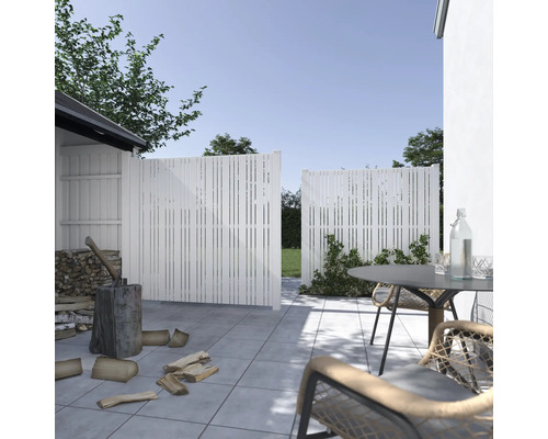 Trädgårdsscen med insynsskydd, vedhuggning och trädgårdsmöbler på en terrass