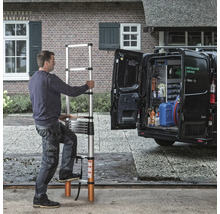 Man använder en utdragbar teleskopstege framför en skåpbil.