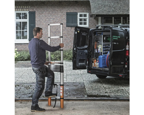 Man använder en utdragbar teleskopstege framför en skåpbil.