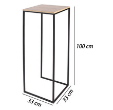 Hög växtpelare med svart metallram och ljus trämönstrad skiva, mått 100 centimeter hög samt 33 gånger 33 centimeter bred.